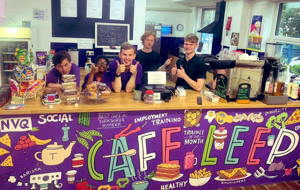 A photo of staff and trainees, posing behind the counter at Cafe Leep